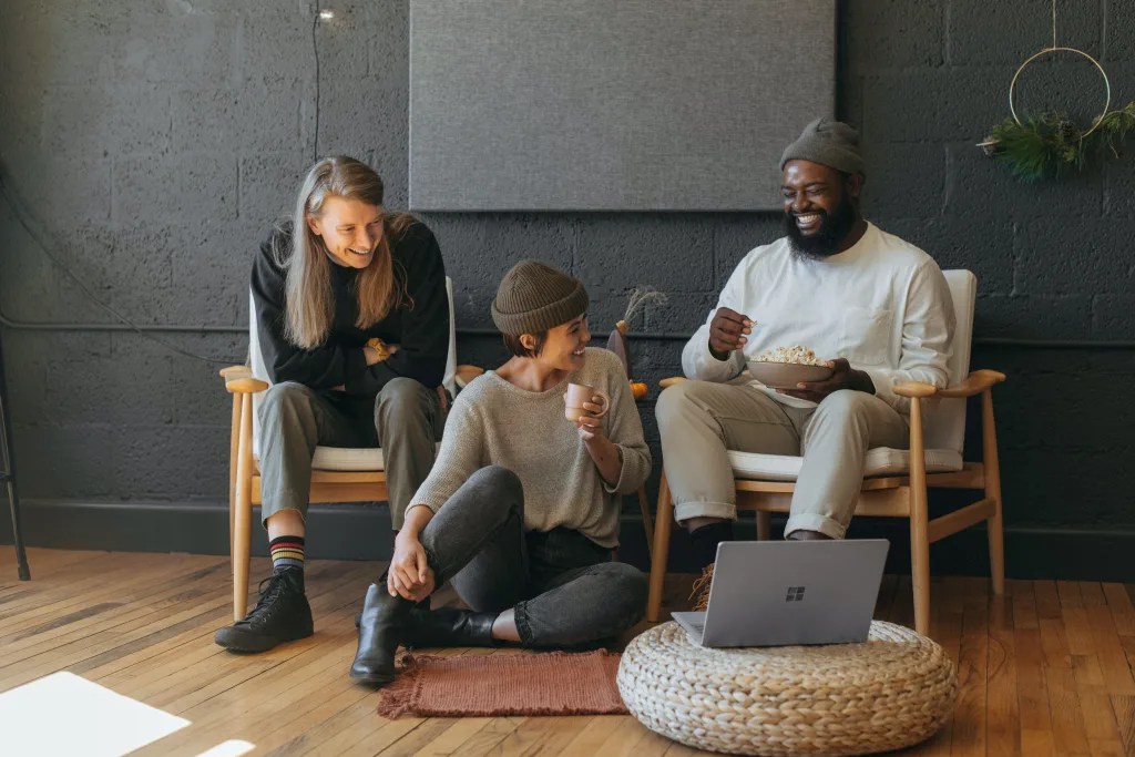 Three people chatting together in front of a computer