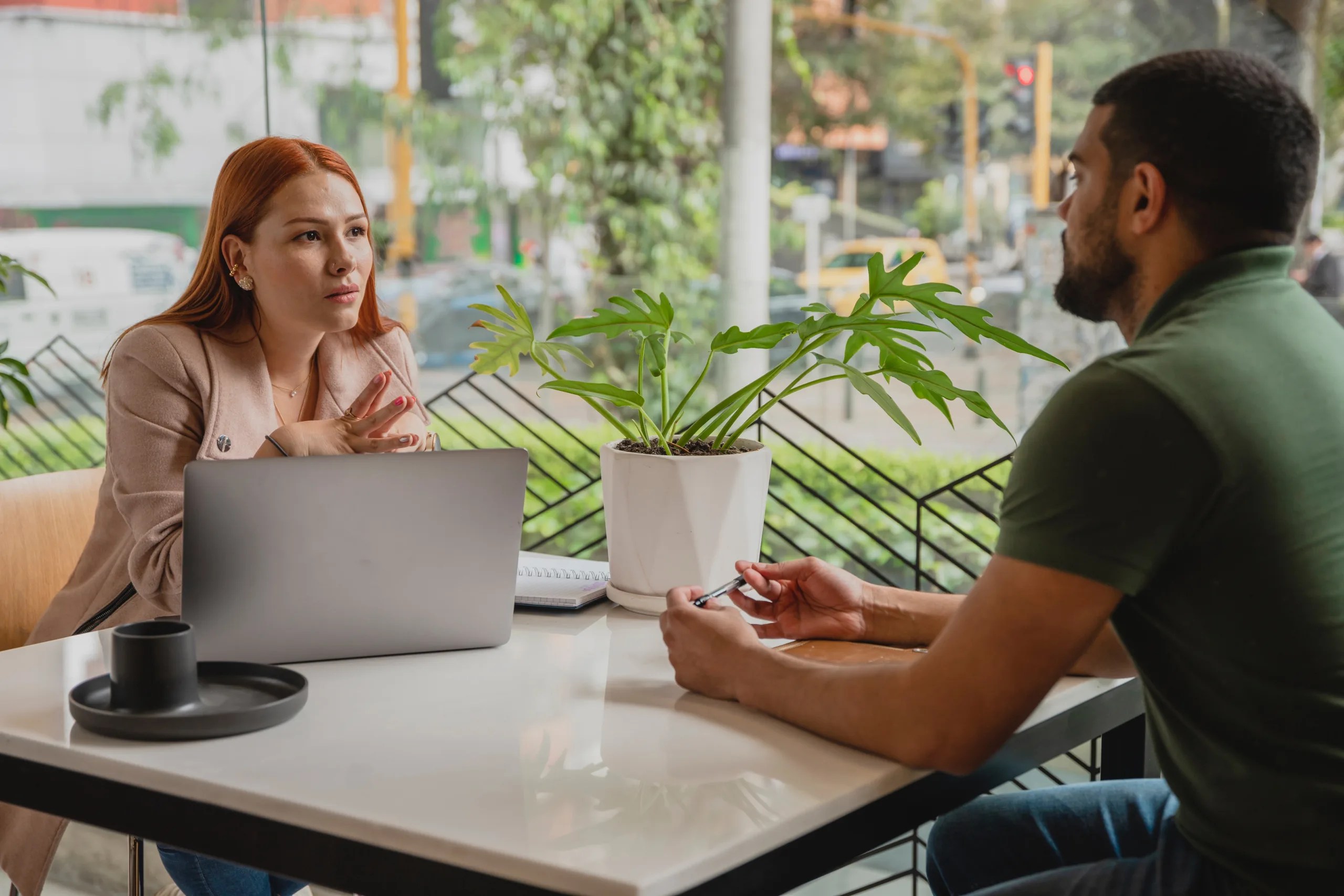 Two people sitting at a table together having a discussion.